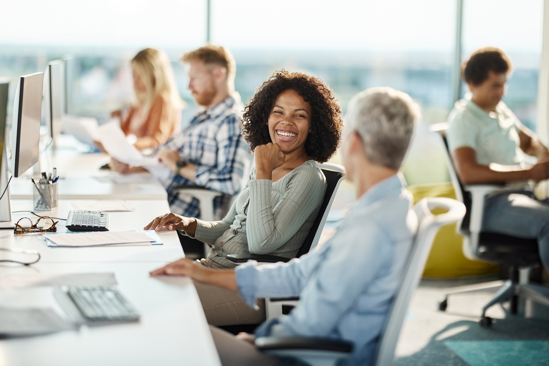 Happy Programmers Talking While Working In The Office